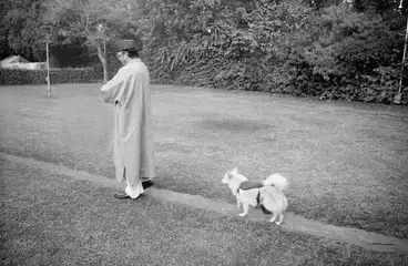 VP Singh walking in the garden at his residence, with a lone follower