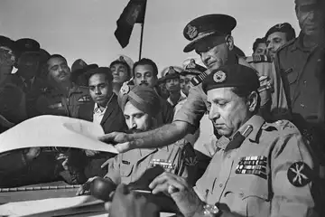 Indian Air Marshal Dewan takes the Instrument of Surrender after it is signed by Pakistani Lt. Gen. Niazi
