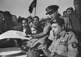 Indian Air Marshal Dewan takes the Instrument of Surrender after it is signed by Pakistani Lt. Gen. Niazi