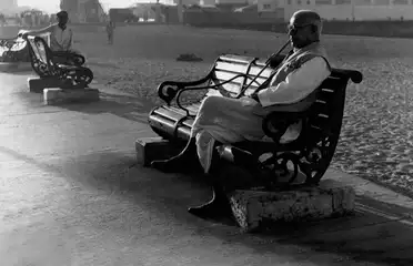An old man sits on a bench during his morning walk along the Marine Drive, Bombay
